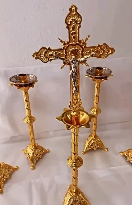 Crucifixo de altar dourado entre dois castiçais