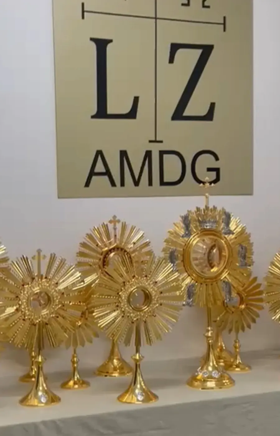 Letreiro LZ AMDG sobre uma bancada com ostensórios dourados