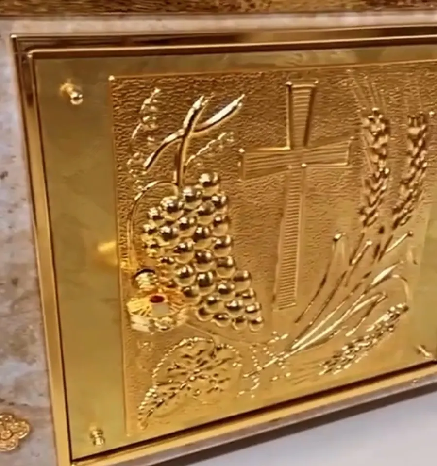 Sacrário retangular dourado com relevo de cruz, espigas e uvas